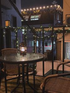 a table with a lantern on a balcony with lights at Jnineguesthouse in Seoul