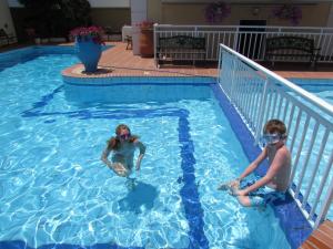 two children are playing in a swimming pool at Bueno Hotel in Platanes