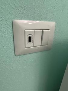 a white light switch on a green wall at Edeler House in Pula +8 photos