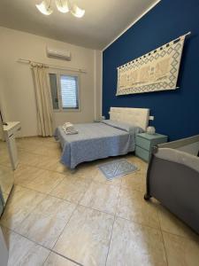 a bedroom with a bed and a blue wall at Edeler House in Pula