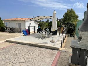 a patio with a white umbrella and a table and a table and chair at Edeler House in Pula