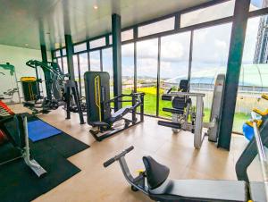 einen Fitnessraum mit mehreren Laufbändern und einem großen Fenster in der Unterkunft Lovina 3508 at Pollux Meisterstadt in Batam Center