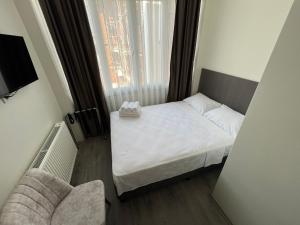 a small bedroom with a white bed and a window at Maritsa Hotel in Edirne