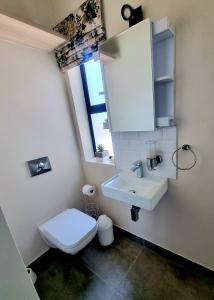 a bathroom with a white sink and a toilet at 33D Kabeljauws Beach in Jeffreys Bay