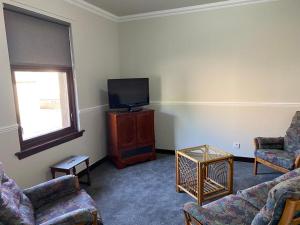 a living room with couches and a flat screen tv at Welltrees Apartments 10 Dailly Road in Maybole