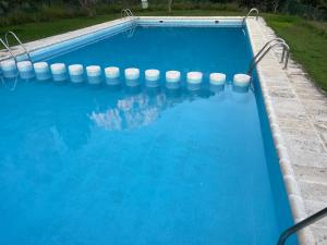 a swimming pool with blue water and white buoys at Casas Rurales Mirador del Mundo in Yeste