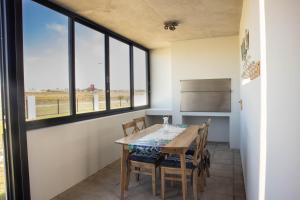 a dining room with a table and some windows at 33D Kabeljauws Beach in Jeffreys Bay