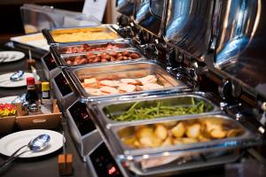a buffet with several trays of food on a table at DoubleTree by Hilton Turin Lingotto in Turin