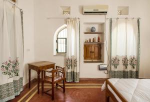 a bedroom with a bed and a table and a chair at Kawa Guest House in Jaipur