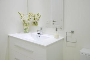 ein Waschbecken im Badezimmer mit einer Vase mit Blumen darauf in der Unterkunft Canary Lofts Rambla in Santa Cruz de Tenerife