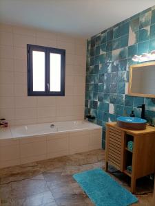 ein Badezimmer mit einer Badewanne, einem Waschbecken und einem Spiegel in der Unterkunft Maison neuve 200m2 climatisée, proche de la plage et des commerces in Audenge