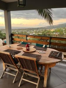 d'une table et de chaises en bois sur un balcon avec vue. dans l'établissement Villa Nirvana, à Saint-Paul