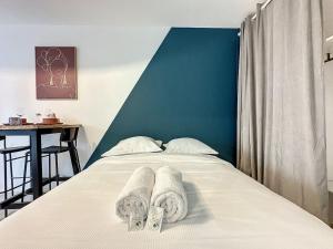 a bedroom with a bed with towels on it at Cosy appart - Cité international - Fays 1 in Caluire-et-Cuire