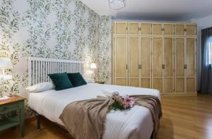 um quarto com uma cama grande e papel de parede floral em Santa Catalina Patio Andaluz Moderno em Sevilha
