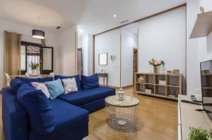 uma sala de estar com um sofá azul e uma mesa em Santa Catalina Patio Andaluz Moderno em Sevilha