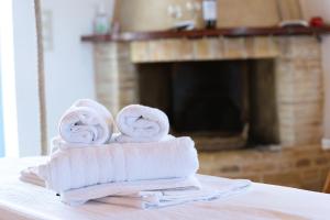 a stack of towels on a table with a fireplace at Kalomoira's Apartments in Elafonisos +49 photos