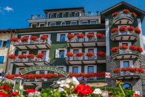 a building with red flowers in the balconies on it at Hotel San Lorenzo in Bormio