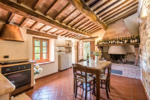 a kitchen with a wooden table and a fireplace at Appartamento Gemma Bianca-tavoleto in Castiglione dʼOrcia