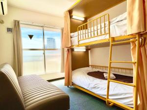 Zimmer mit Etagenbett, 2 Etagenbetten und einem Fenster in der Unterkunft Sakura Hotel Nippori in Tokio