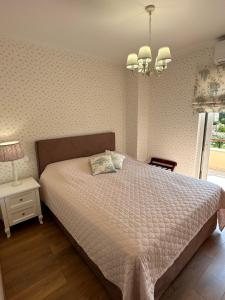 a bedroom with a large bed and a chandelier at Villa Myrto Nafpaktos in Nafpaktos