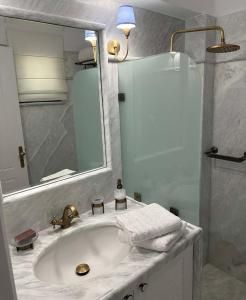 a white bathroom with a sink and a shower at Villa Myrto Nafpaktos in Nafpaktos