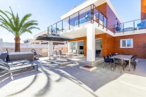 a house with a patio with a table and chairs at Casa Bos Flamingo Pool and Jacuzzi in Puerto Marino