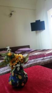 un jarrón lleno de flores sentado encima de una cama en Apartment on Tabukashvili Street, en Tiflis