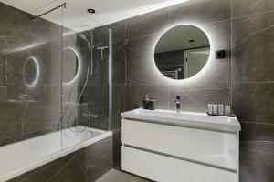 Wenum的住宿－Huisje Wenum - Apeldoorn met jacuzzi，一间带水槽、淋浴和镜子的浴室