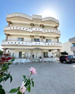 a large building with white chairs in a parking lot at Apartmens Xhenis Lux in Ulcinj