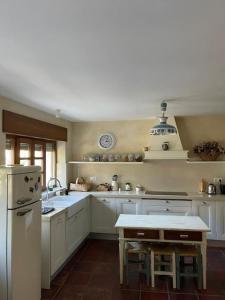 cocina con armarios blancos y nevera blanca en Casa Buganvilla, Comillas, Cantabria, 