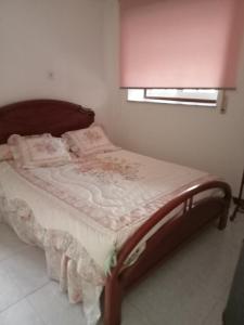 een bed met een houten frame in een kamer bij Casa da Fariñeira in Redondela