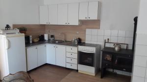 a kitchen with white cabinets and a sink and a stove at Chalupa - Dešov in Desov
