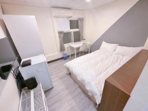 Habitación pequeña con cama y escritorio. en 新獅城商務旅店New Lion City Hotel, en Taipéi