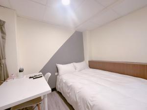 Kama o mga kama sa kuwarto sa 新獅城商務旅館New Lion City Hotel