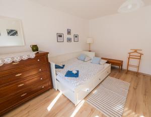 a small bedroom with a bed and a dresser at Lankás Vendégház - Hollókő in Hollókő