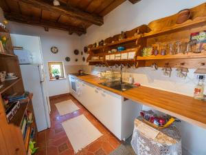 a kitchen with a counter and a sink and a refrigerator at Lankás Vendégház - Hollókő in Hollókő