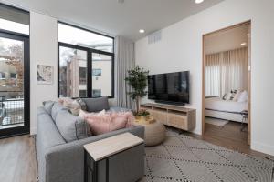 uma sala de estar com um sofá cinzento e uma televisão em The Lofts 660 #203 em Ketchum