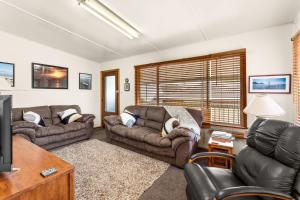 a living room with two couches and a tv at Machiya Rhyll Phillip Island in Rhyll