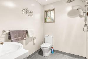 a white bathroom with a toilet and a sink at Machiya Rhyll Phillip Island in Rhyll +4 photos