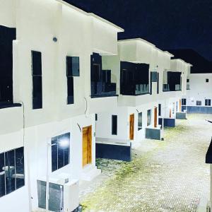 uma linha de edifícios brancos à noite em FayFays Edifice C1 A Luxury 4 Bedroom Terrace Duplex em Lekki