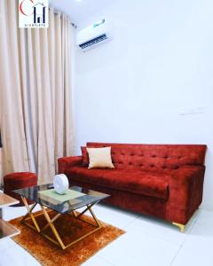 um sofá vermelho numa sala de estar com uma mesa em FayFays Edifice C1 A Luxury 4 Bedroom Terrace Duplex em Lekki