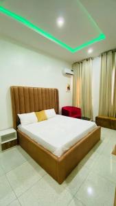 um quarto com uma cama grande e luz verde em FayFays Edifice C1 A Luxury 4 Bedroom Terrace Duplex em Lekki