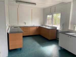 eine leere Küche mit zwei Waschbecken und einem Fenster in der Unterkunft Ubytovna SDC in Valcha