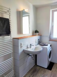 a bathroom with a sink and a washing machine at Apartment mit Garten, 10 min zu Fuß in die Koblenzer Altstadt in Koblenz