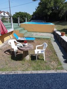 een patio met 2 stoelen, een tafel en een zwembad bij Casa da Fariñeira in Redondela