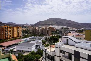 eine Stadt mit Gebäuden und einem Berg im Hintergrund in der Unterkunft Comfy Home in Los Cristianos in Arona