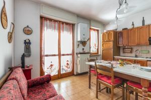 a kitchen and living room with a table and a couch at Asti Lovely Apt - Private Parking & Balconies in Asti