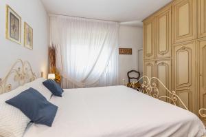 a bedroom with a large white bed with blue pillows at Asti Lovely Apt - Private Parking & Balconies in Asti