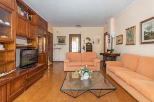 a living room with two couches and a tv at Asti Lovely Apt - Private Parking & Balconies in Asti