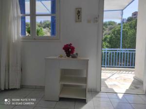 a room with a table with a vase of flowers on it at Valentino in Kalymnos